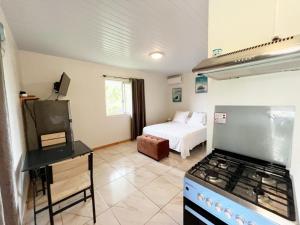 - une cuisine avec cuisinière et un lit dans une chambre dans l'établissement TAHITI - Fare Matavai Piti, à Taravao