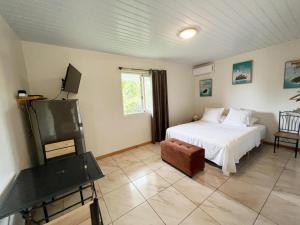 a bedroom with a bed and a television in it at TAHITI - Fare Matavai Piti in Taravao