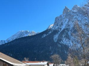 a snow covered mountain in front of a building at Ferienwohnung Seidl Wohnung Violine in Mittenwald