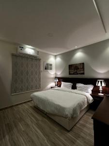 a bedroom with a large bed and two lamps at العنوان للإقامة بتبوك The Address Residence -Tabuk in Tabuk