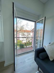 a living room with a large window and a couch at The Swallows Nest in Lisbon