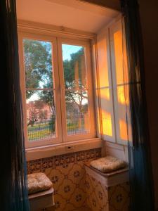 una finestra in una stanza con due posti davanti di Casa Vovo a Lisbona