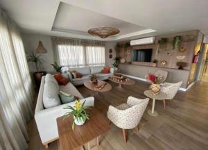 uma sala de estar com um sofá, mesas e cadeiras em Apartamento luxuoso a poucos metros da praia em Salvador