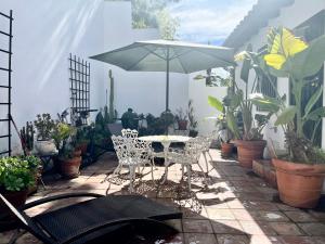 a patio with a table and an umbrella and plants at Hollywood Hills Homestay in Los Angeles