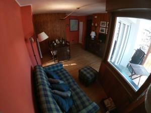 sala de estar con sofá azul y ventana en Appartamento Dolonne Courmayeur, en Courmayeur