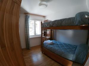 a bedroom with two bunk beds and a window at Appartamento Dolonne Courmayeur in Courmayeur