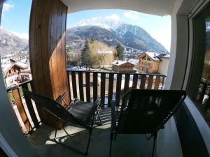 a balcony with two chairs and a view of a mountain at Appartamento Dolonne Courmayeur in Courmayeur