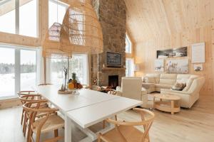 Chertsey的住宿－Chalet le Chardonnay - Spa , Foyers , Accès plage Lac-Jaune，厨房以及带白色桌椅的起居室。