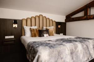 a bedroom with a large bed with a large headboard at Hotel Amerika in Hoek van Holland