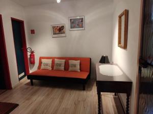 - un salon avec un canapé orange et une table dans l'établissement FeWo 1 im ehemaligen Geschenkehaus, à Monschau