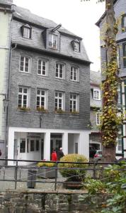 a large gray building with people standing in front of it at FeWo 1 im ehemaligen Geschenkehaus in Monschau