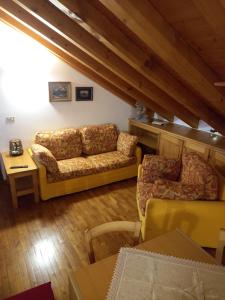 un soggiorno con divano e tavolo di Deliziosa mansarda con vista Dolomiti a San Vito di Cadore