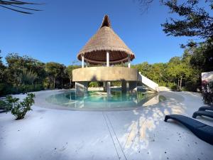 uma grande piscina com um gazebo em Casa Debra em Puerto Morelos
