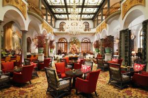 a hotel lobby with tables and chairs and a chandelier at The St. Regis Florence in Florence