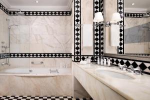 a bathroom with two sinks and a tub and a mirror at The St. Regis Florence in Florence