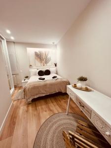 a bedroom with a bed and a table in it at EL CAPRICHO DEL ARCO_Apartamentos Burgos Catedral in Burgos