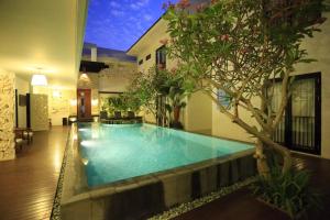 una piscina en medio de una casa en Bali Sunset Villa, en Seminyak