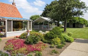 een tuin met bloemen en een prieel bij Cozy Home In Merkem With Wifi in Merkem