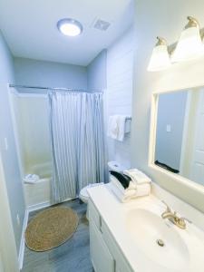 een badkamer met een wastafel, een toilet en een spiegel bij Duplex allows for one or both sides to be rented! Suitable for small or large families! in Gulf Shores