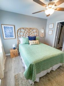 a bedroom with a large bed with a green bedspread at Duplex allows for one or both sides to be rented! Suitable for small or large families! in Gulf Shores