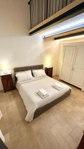 een slaapkamer met een groot bed en 2 handdoeken bij Appartamento ad Orvieto in Orvieto