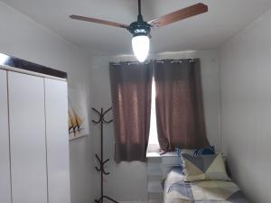 1 dormitorio con ventilador de techo y ventana en Apartamento, vista cidade, en Salvador