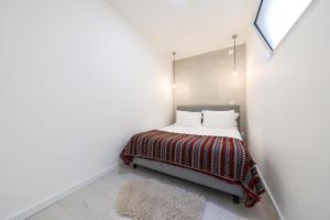 a bedroom with a bed with a red and white blanket at Casa da Candida one place, many things in Nazaré