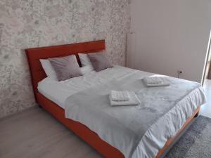 a bedroom with a bed with two towels on it at Delightful Studio Brâncuși in Bucharest