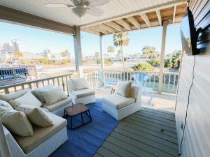 a screened in porch with couches and a flat screen tv at Modern, 3 BR Private House within Walking Distance to the Beach! in Gulf Shores