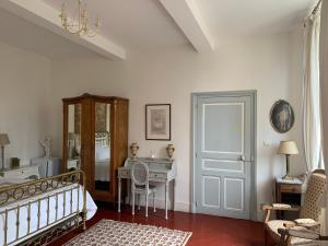 a bedroom with a bed and a desk and a table at Le Moulin du Carla in Lavaur