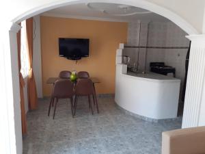 eine Küche mit einem Tisch und einem Waschbecken sowie einen TV in der Unterkunft Fantástica cartagena accesible para todos in Cartagena de Indias