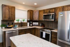 a kitchen with wooden cabinets and a stainless steel refrigerator at Close to RMNP, Estes,& Amenities in Estes Park