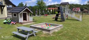 a park with a playground with a sandbox and a slide at Domki letniskowe "DORCIA" in Łeba