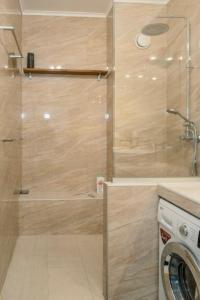 a shower with a glass door in a bathroom at Grand Large - Premium suite in Papeete