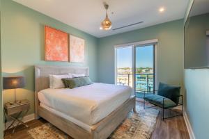 een slaapkamer met een bed en een groot raam bij Glamorous 5 BR Condo right next to The Hangout! in Gulf Shores