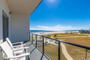 a balcony with two chairs and a view of the beach at Modern 4 BR Luxury Condo with Rooftop Pool Next to the Hangout! in Gulf Shores