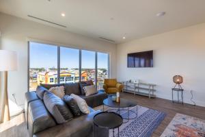 a living room with a couch and a large window at Modern 4 BR Luxury Condo with Rooftop Pool Next to the Hangout! in Gulf Shores