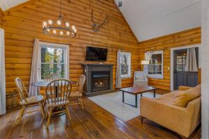 a living room with a table and a fireplace at The Wells Cashiers in Cashiers