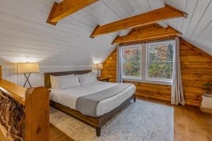 a bedroom in a log cabin with a bed and a window at The Wells Cashiers in Cashiers