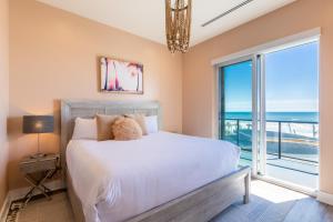 a bedroom with a bed and a large window at Beachfront, Luxury 4 BR Condo with Gulf views next to the Hangout! in Gulf Shores