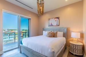 a bedroom with a bed and a large window at Elegant 4 BR Luxury Condo with Rooftop Pool Next to the Hangout in Gulf Shores