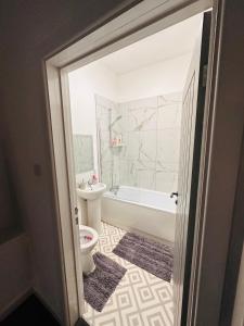 a bathroom with a tub and a toilet and a sink at City Blessed Aptm 2 with free parking in North Shields +3 photos