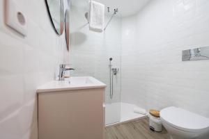 a white bathroom with a sink and a toilet at Estúdio Cândida, One place … in Nazaré +15 photos
