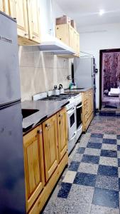 a kitchen with wooden cabinets and a stove and refrigerator at Hostel Piltri in El Bolsón