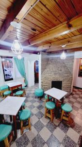 a room with tables and chairs and a fireplace at Hostel Piltri in El Bolsón