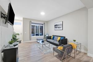 uma sala de estar com um sofá e uma televisão em Upscale Urban Oasis- Stylish Townhome Getaway-Comfort for Family, Work and Longer Visits em Edmonton