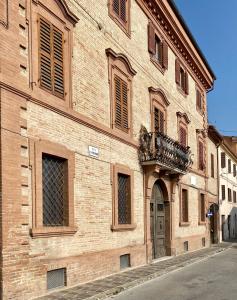 ein großes Backsteingebäude mit einer Tür auf einer Straße in der Unterkunft Il Barchio loft in un palazzo di fine 800 a Jesi in Iesi