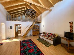 a living room with a couch and a staircase at Pensiunea Casa Țărănească in Satu Bătrîn