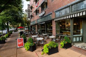 a sidewalk with tables and chairs in front of a store at The Armstrong Hotel in Fort Collins