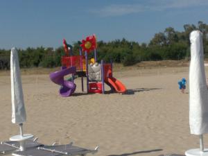un parque infantil en la arena en una playa en Residence Nettuno, en Campomarino